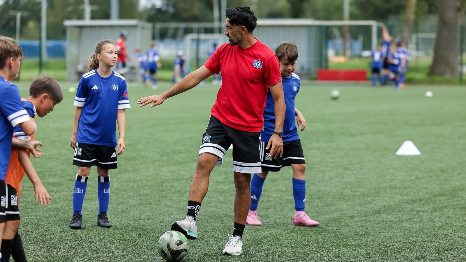 Football Lab Hamburg homepage — Mustafa Zazai coaching a group of children on a pitch